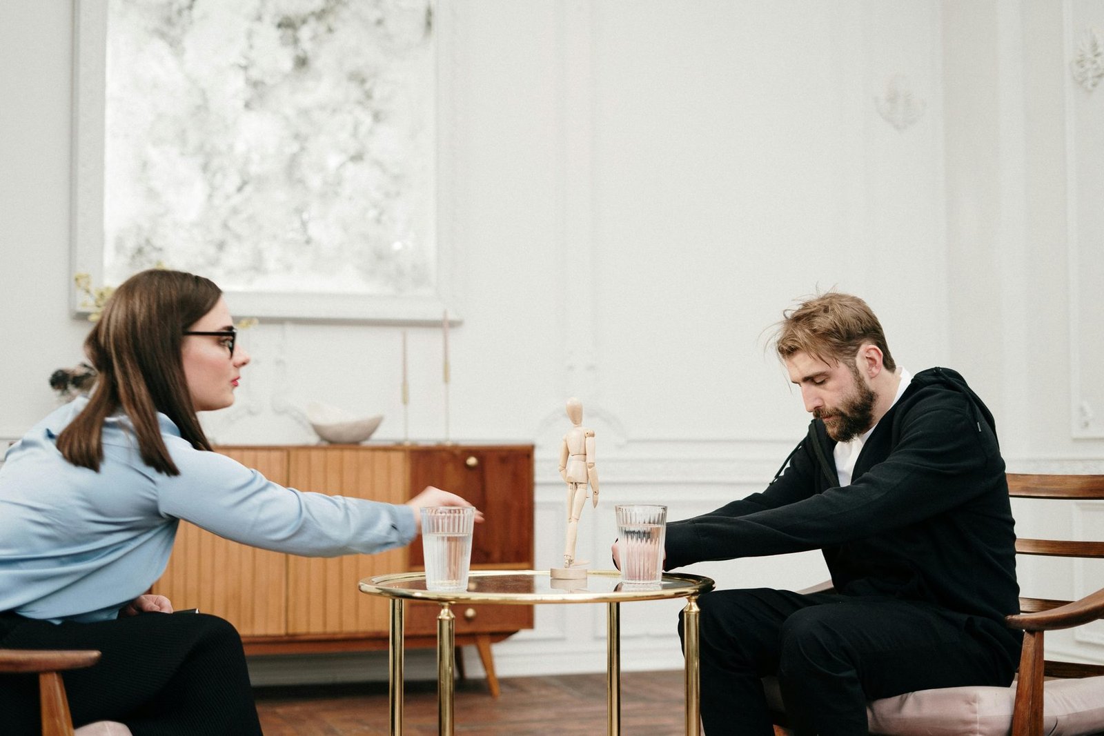 A calm, daylight office visit — two people talking across a table.